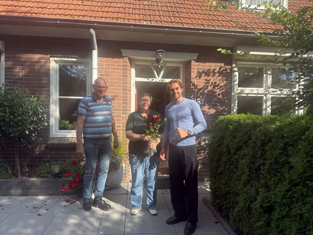 Klanten voor hun woning met een bos bloemen