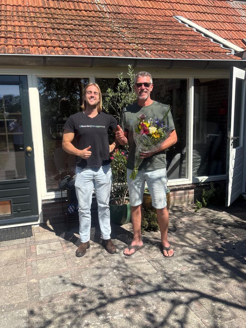 Klant met een bos bloemen voor zijn woning, samen met ons team